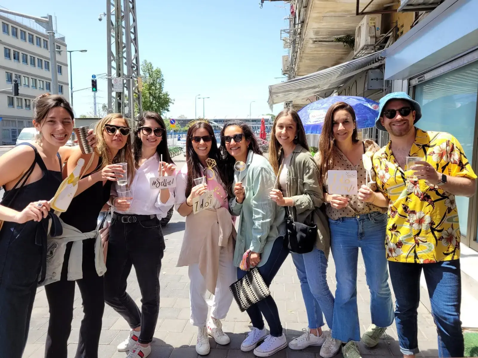 קבוצת חברים מחייכת ברחוב עם אביזרים למסיבה